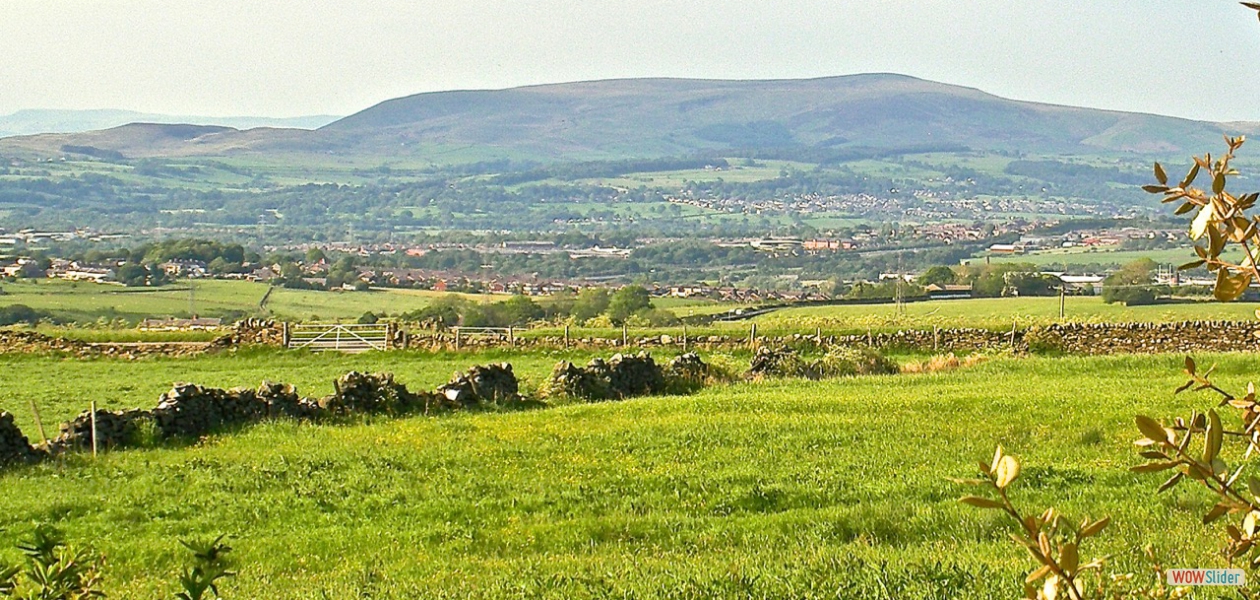 Our lounge's view of Pendle Hill with the peaks of the Yorkshire Dales in the distance. Pendle Hill is famous for the witches of Pendle and the trials – similar to the Salem witches. At the end of a tiring day it is just great to sit in the lounge or garden with a quality German beer or a glass of red wine and watch the grass grow. An ideal house swap location.